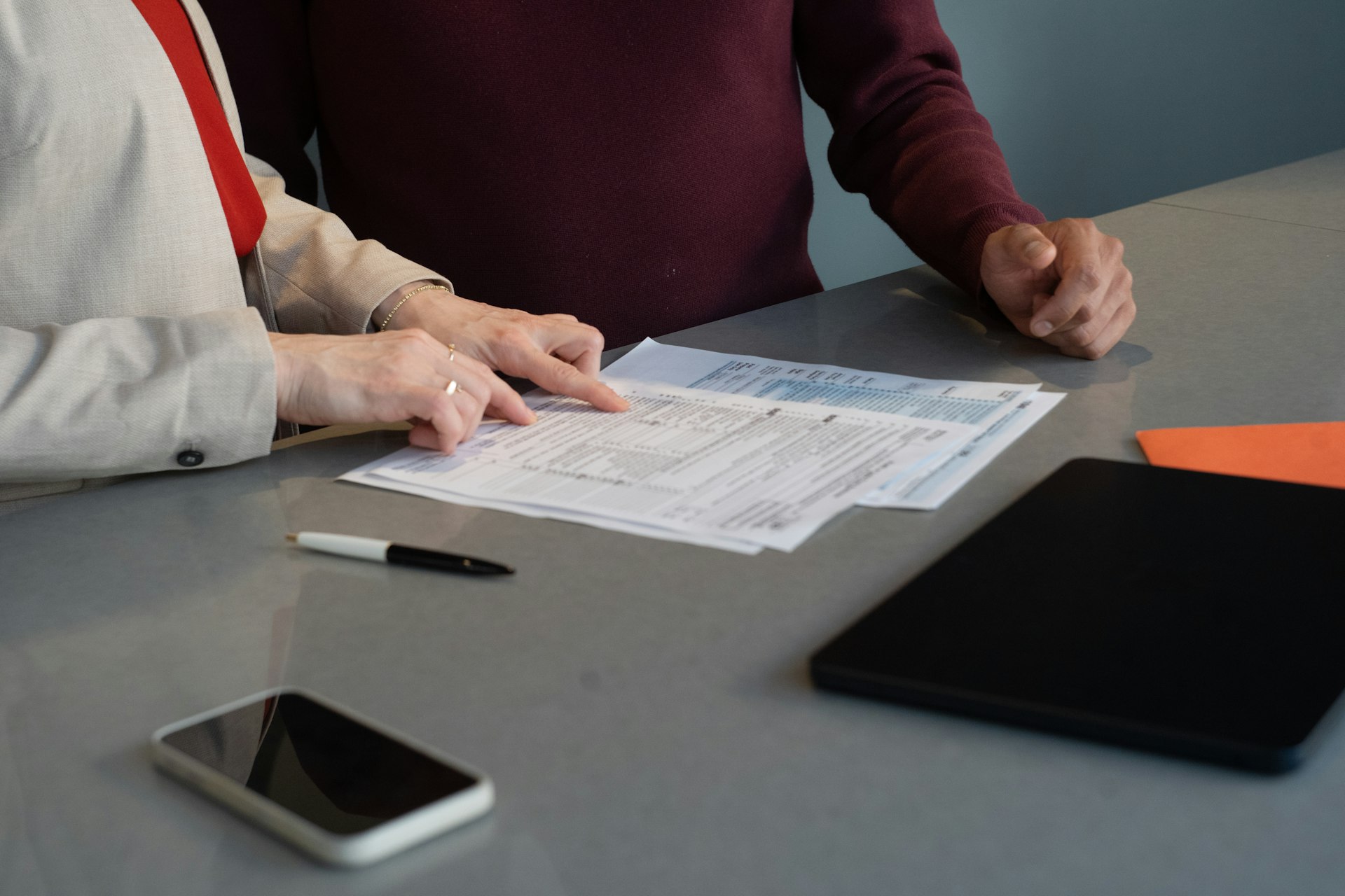 Someone reading contract documents at a desk