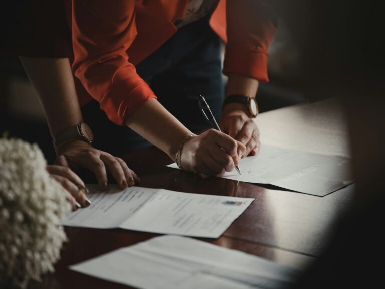 A pen resting on contract paperwork