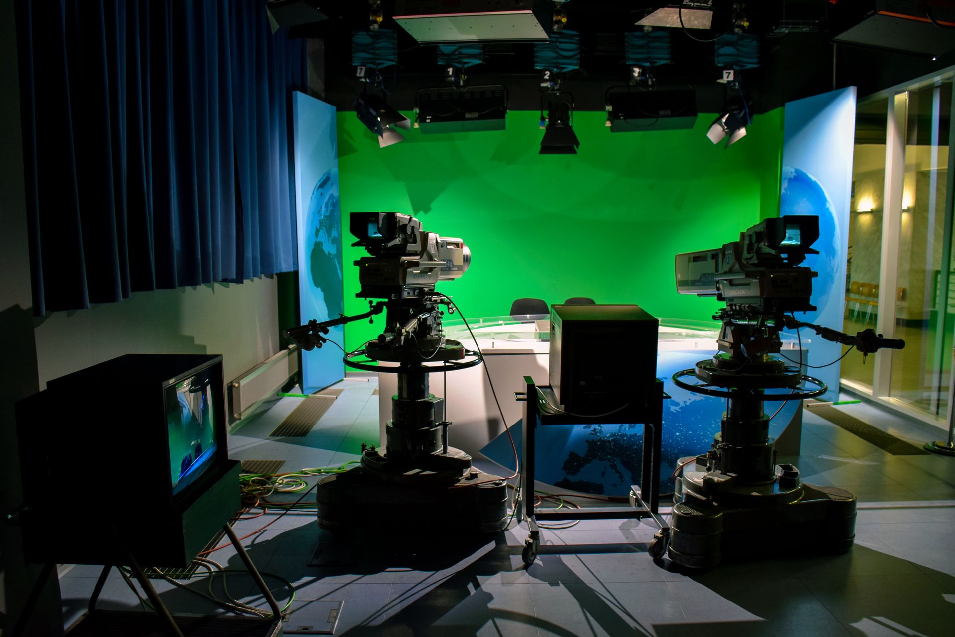 A wall of screens in a newsroom showing live output