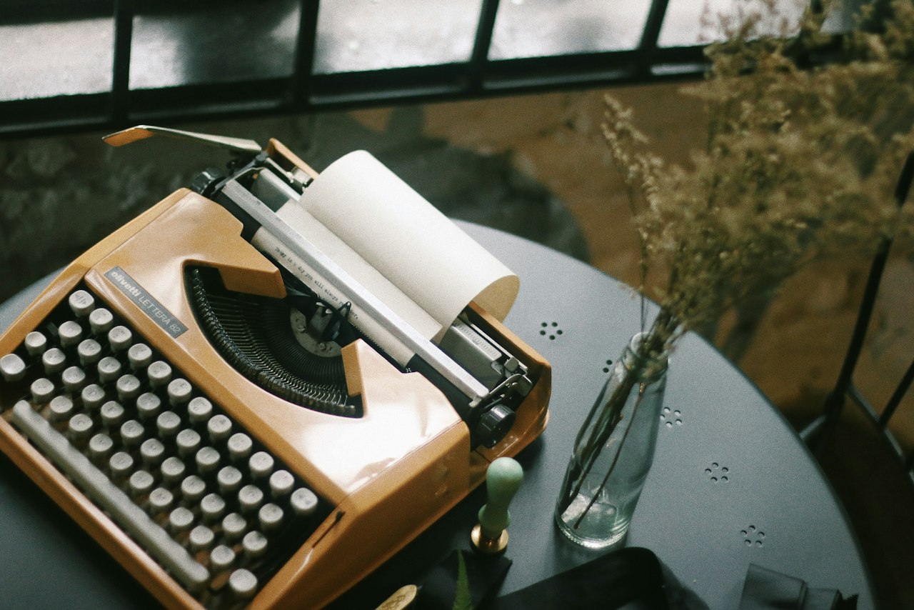 An old typewriter on a wooden writing desk