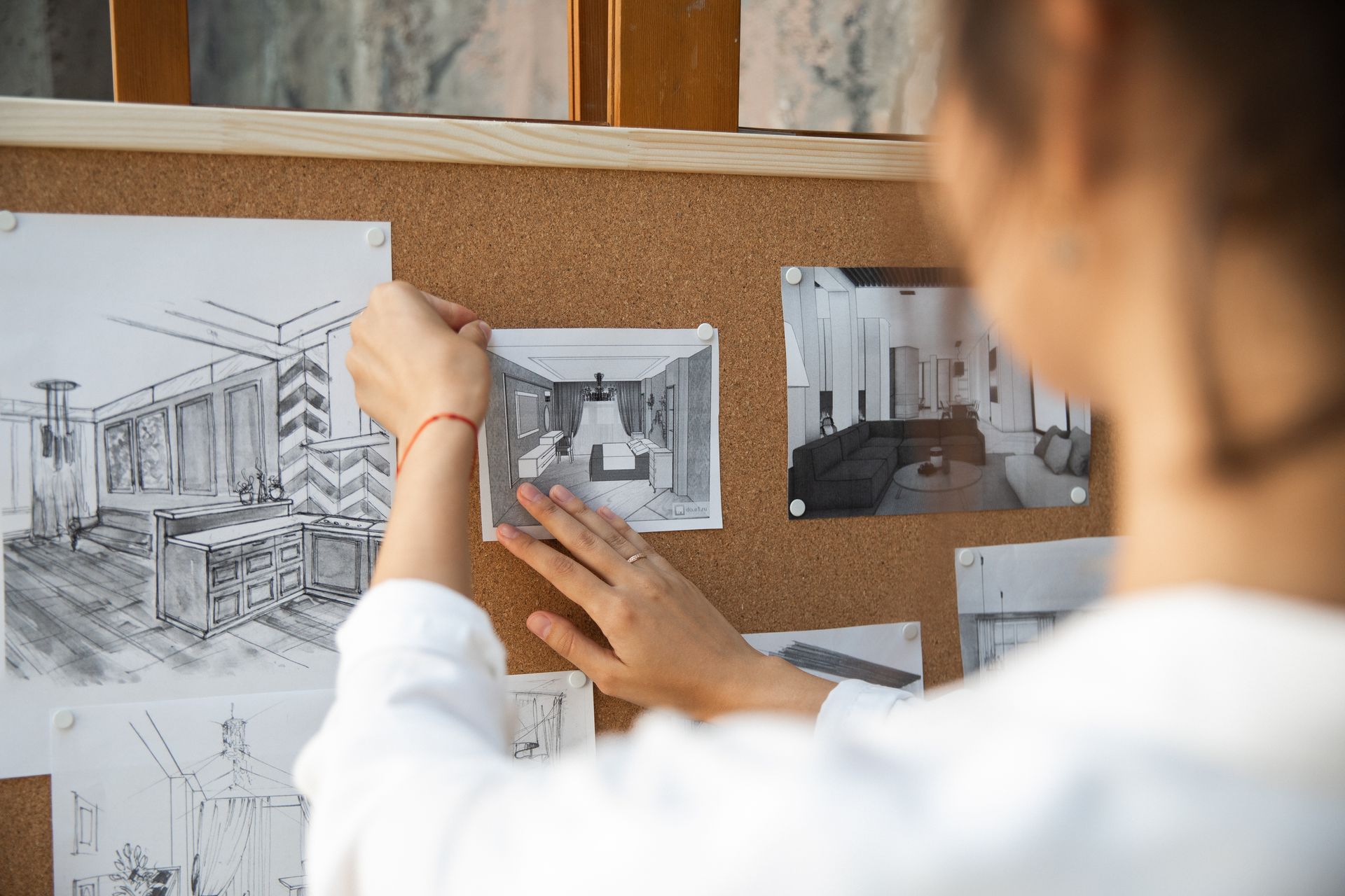 Paper wireframe sketches pinned to a corkboard