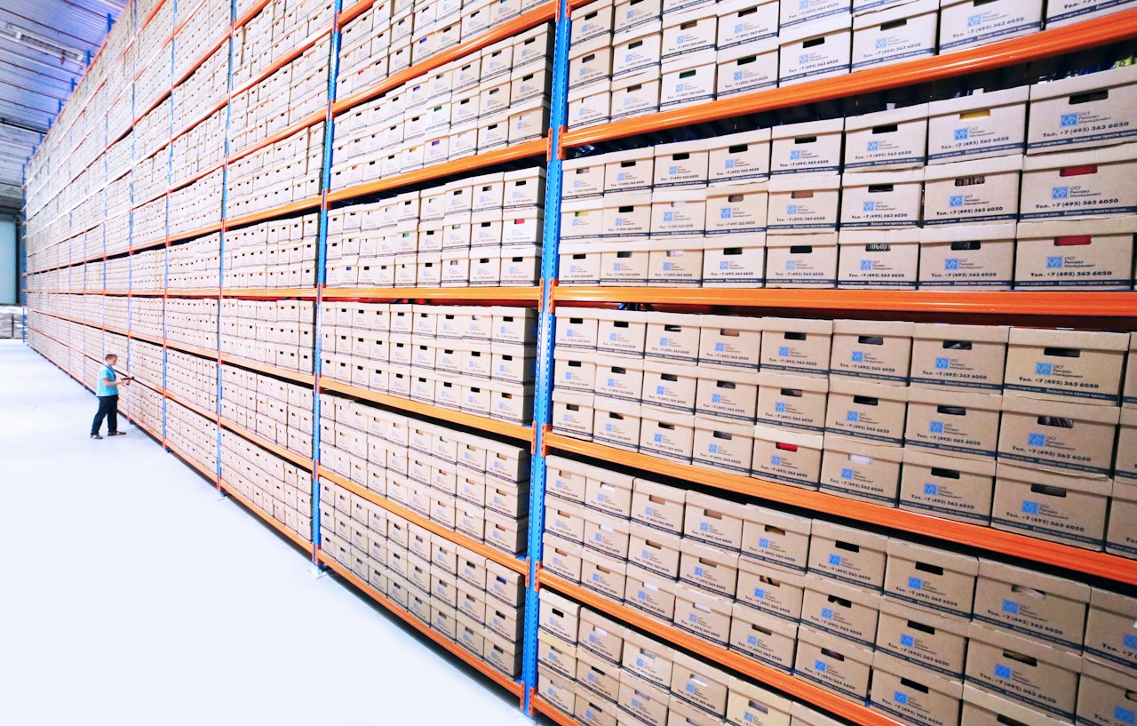 Rows of labelled archive boxes on deep shelving