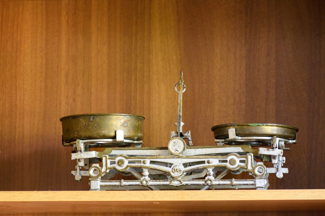 An antique brass balance scale with its weights