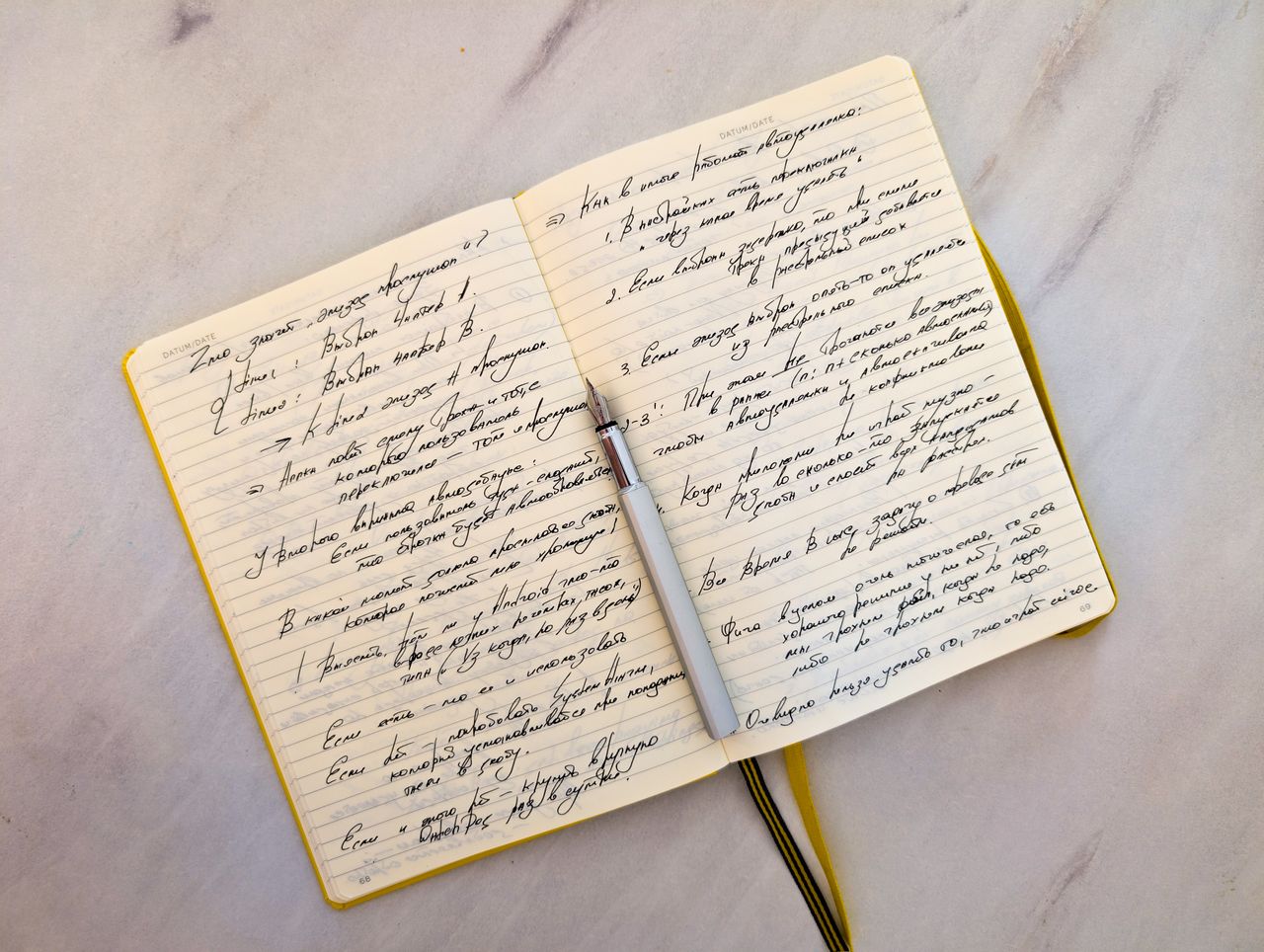 A notebook filled with handwritten notes beside a pen