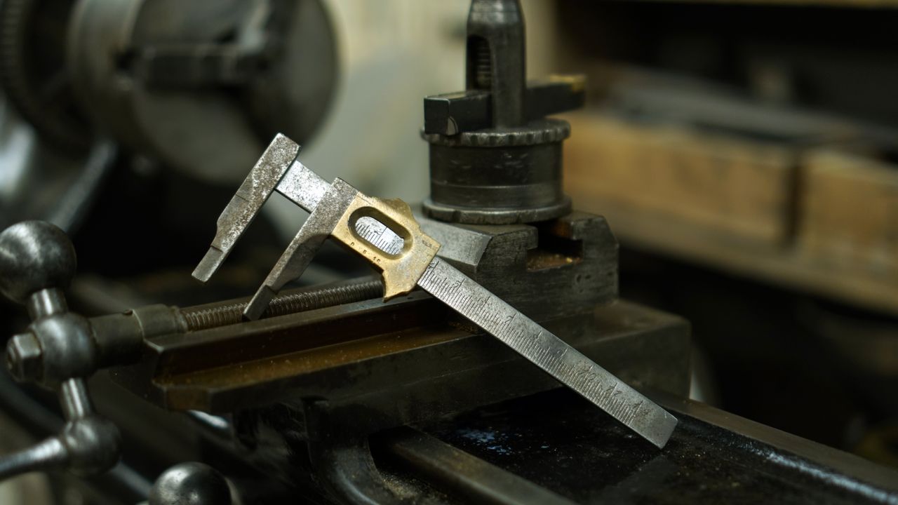 A vernier caliper closed around a metal part