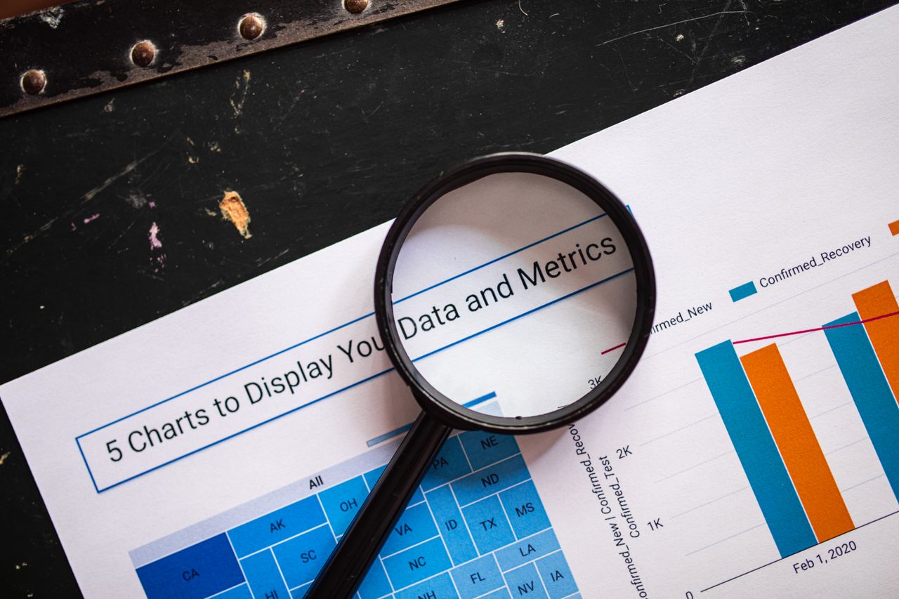 A magnifying glass resting on a printed line chart