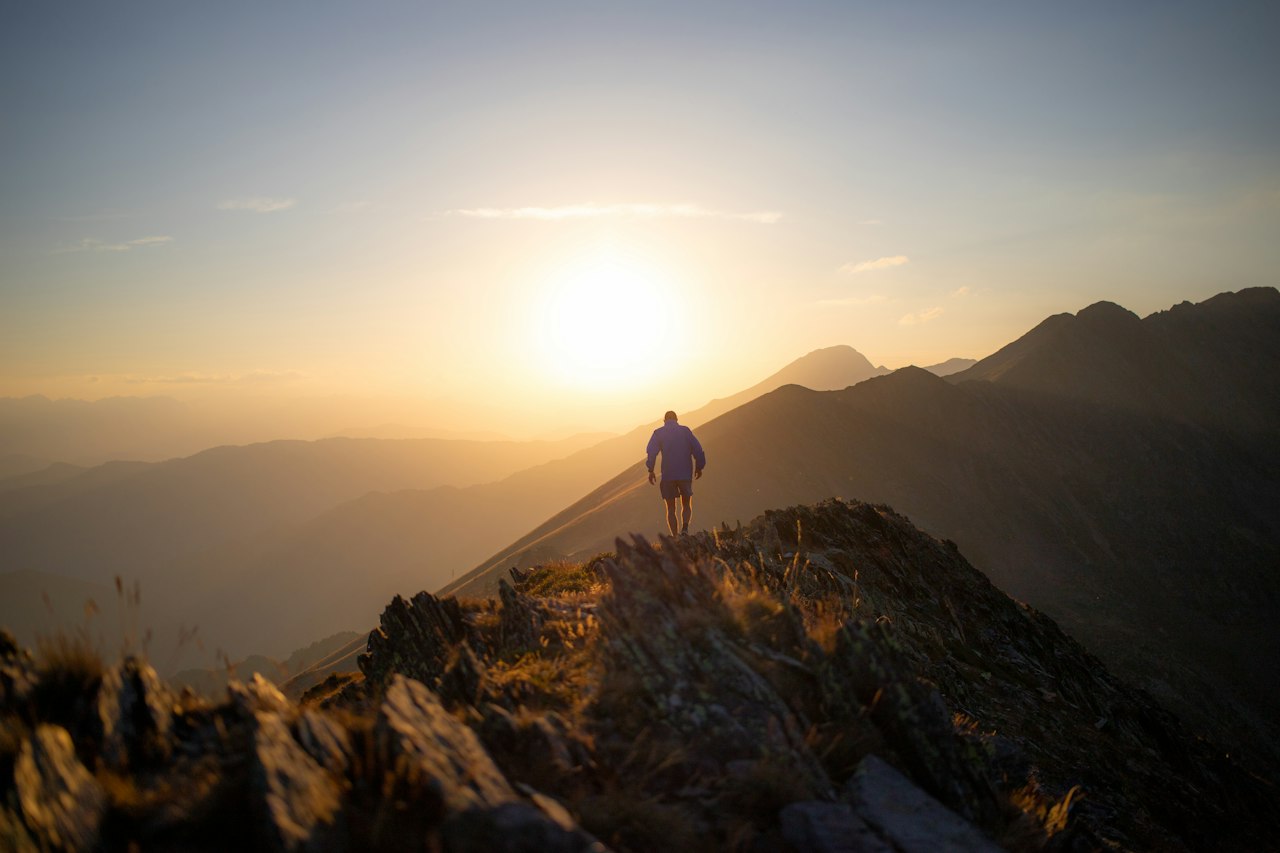 A lone hiker on a ridgeline at first light
