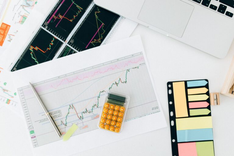 Research notes beside analytics on a laptop