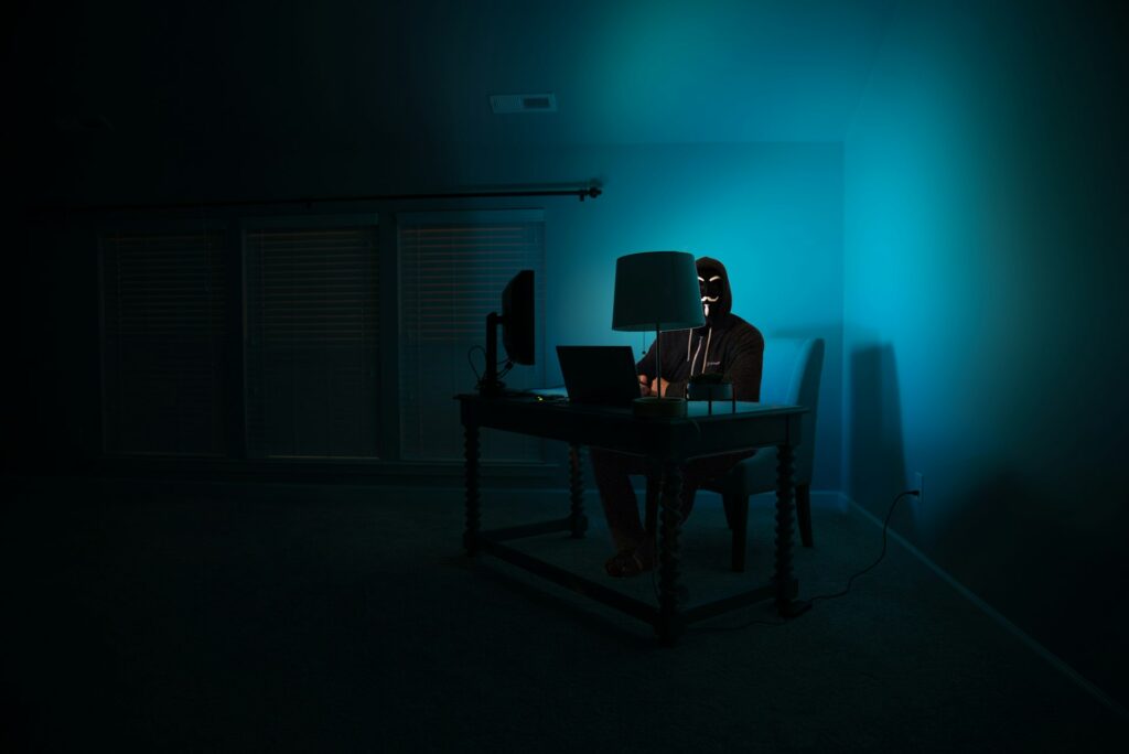 A figure at a dark desk