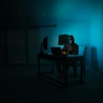 A figure at a dark desk