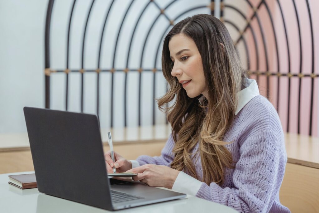 A blogger writing at a desk with a laptop