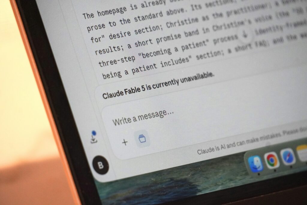 A person typing a prompt into an AI chat on a laptop