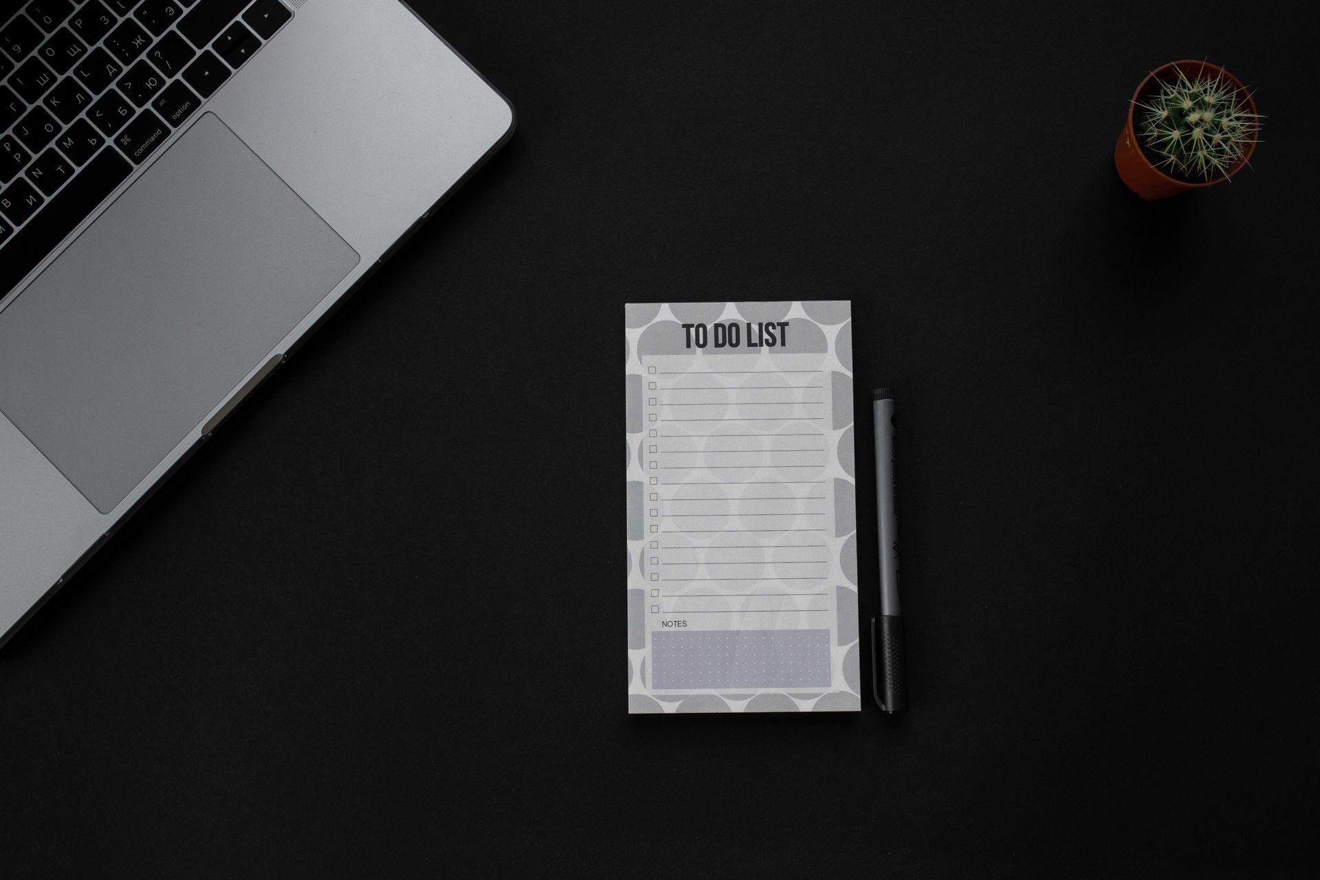 A migration checklist on a notepad beside a laptop