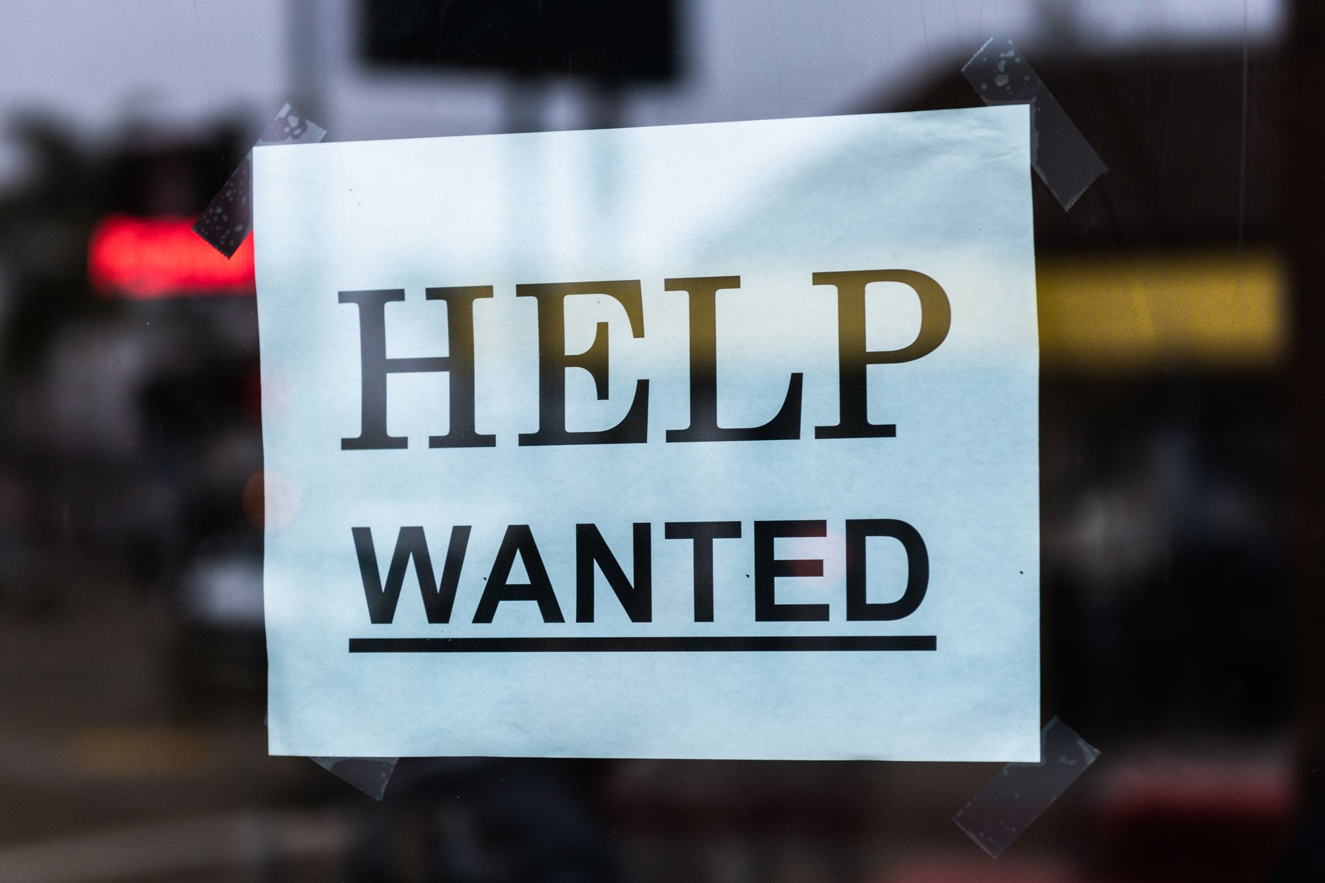 A hiring sign in a shop window