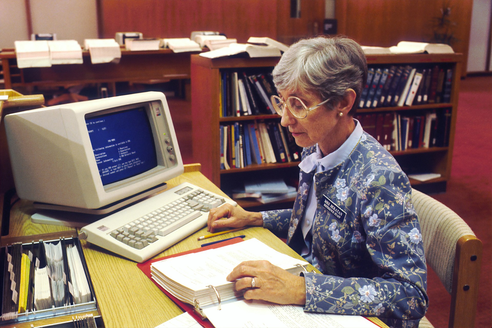 A reporter writing at a newsroom computer