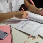 A reviewer testing a product at a desk with notes