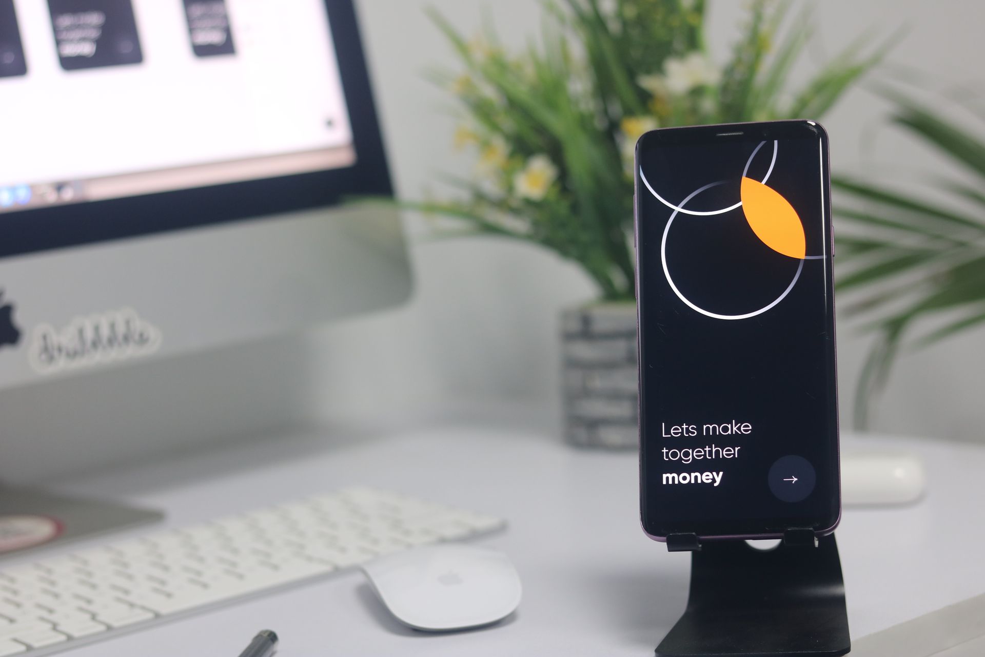 A smartphone next to desktop computer