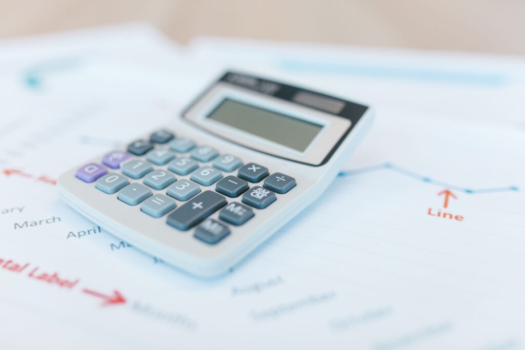 A calculator beside a profit report