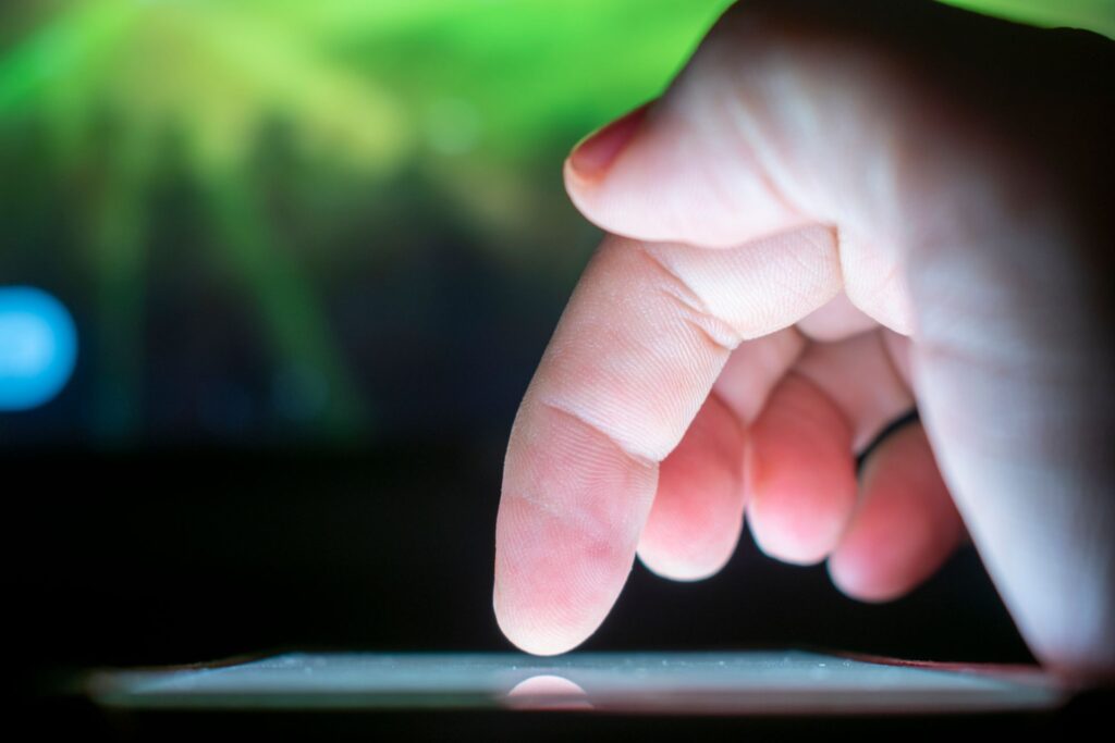 A finger tapping a button on a smartphone
