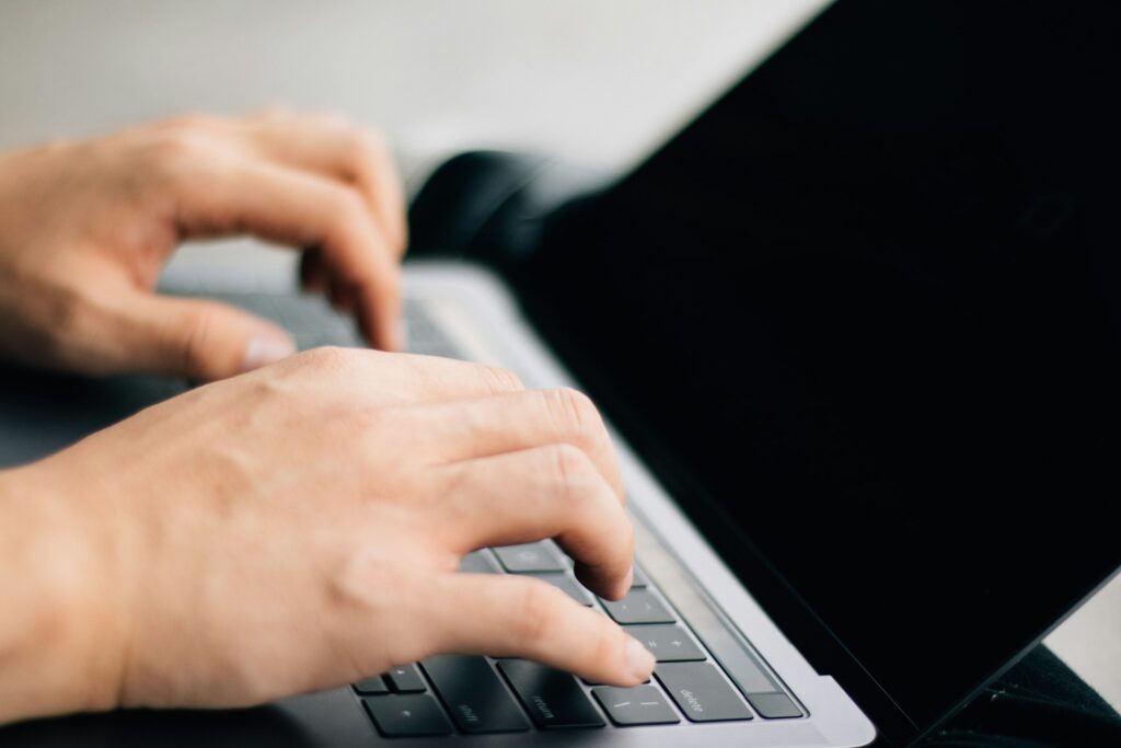 A programmer typing code on a laptop
