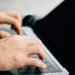 A programmer typing code on a laptop