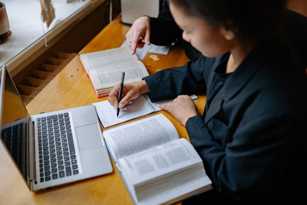 A student studying with a laptop and notes