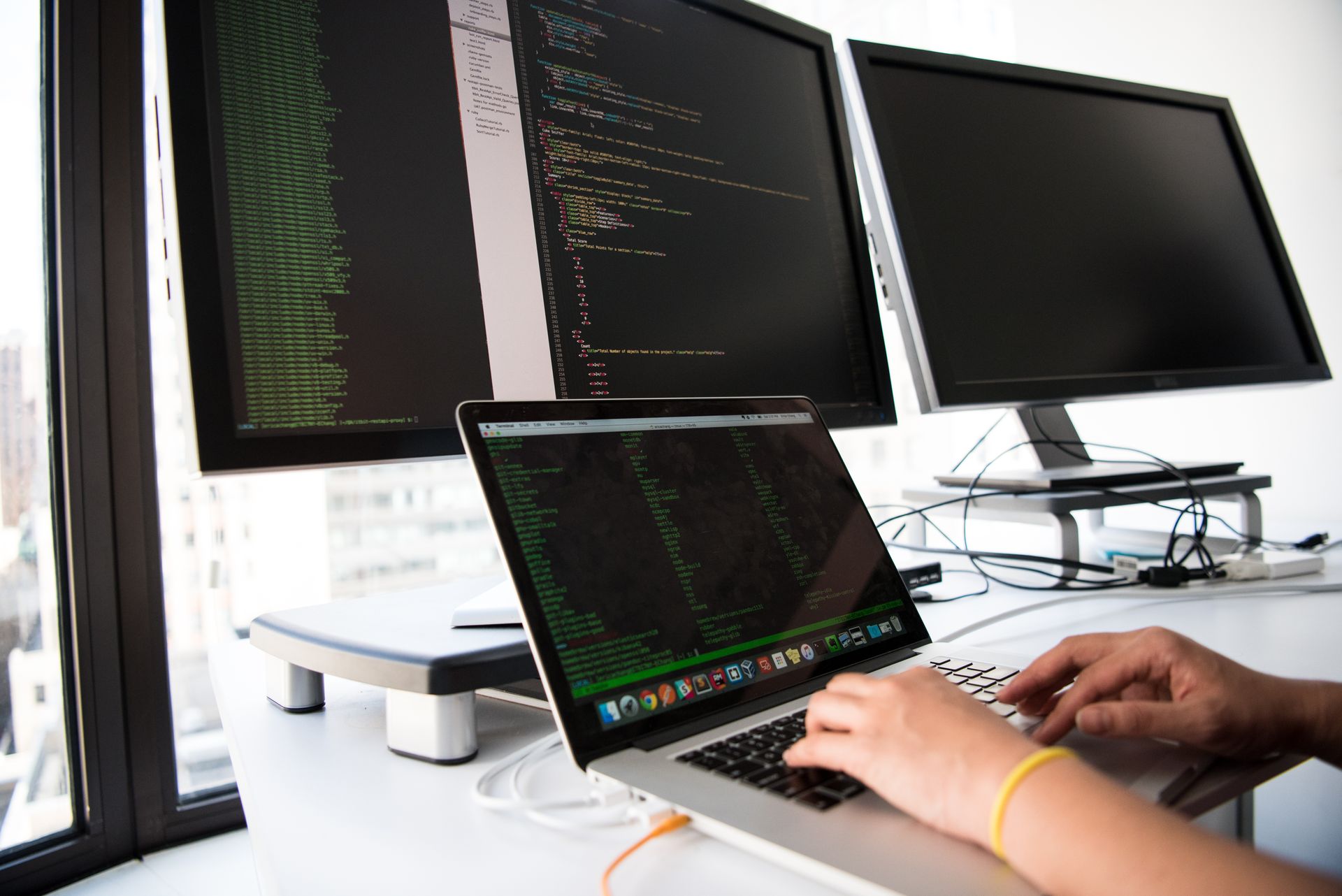 A programmer at multiple monitors