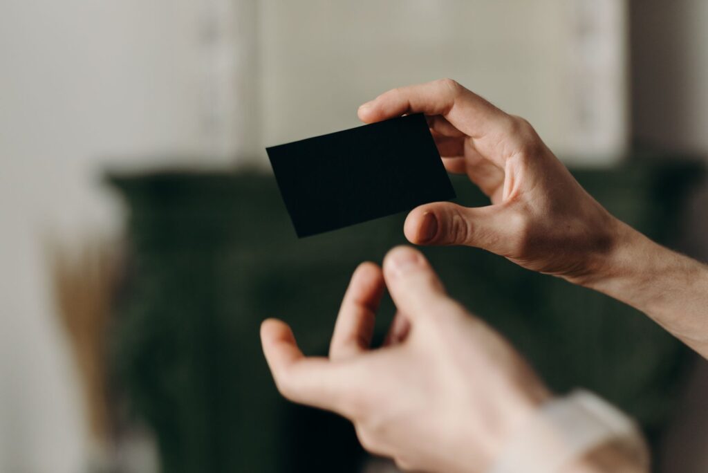 Two hands exchanging business cards