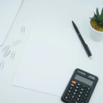 A calculator and coins on a desk