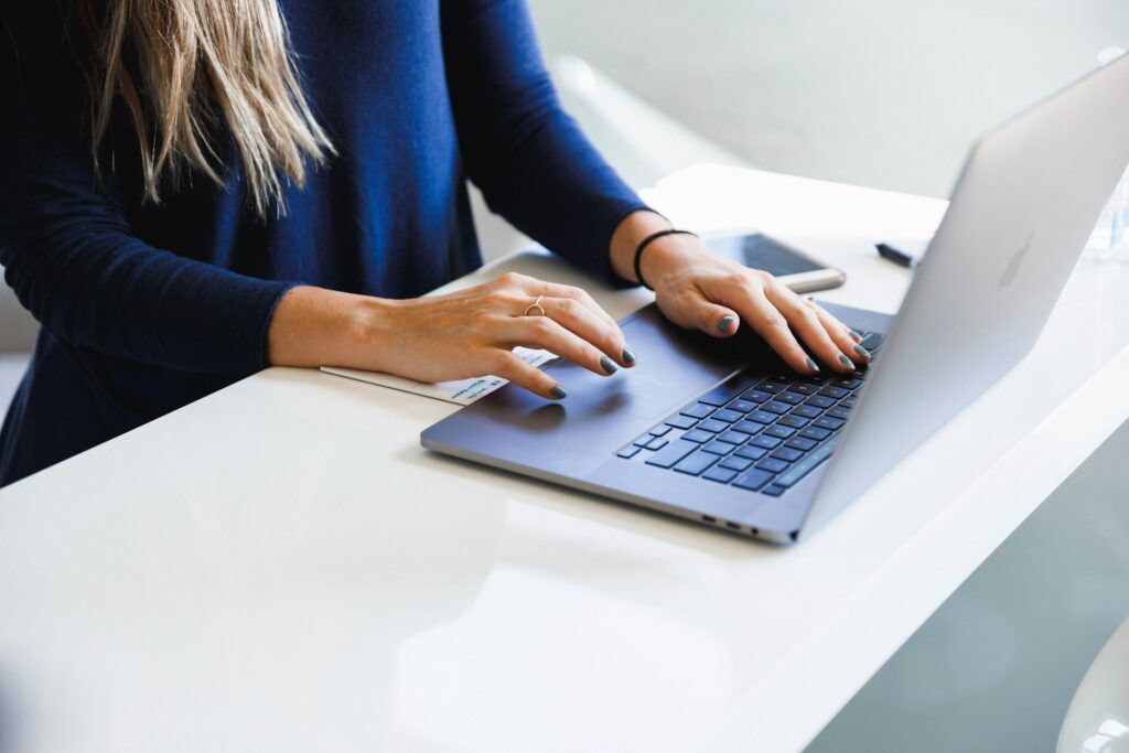 Someone typing a search query on a laptop