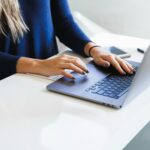 Someone typing a search query on a laptop