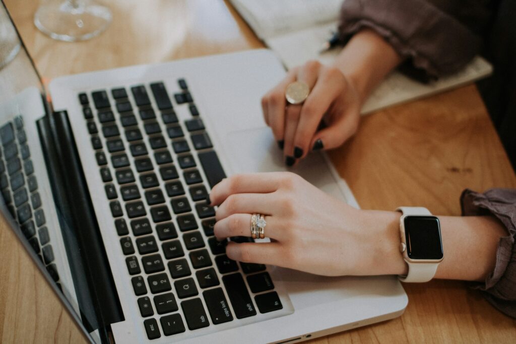 A writer drafting a post with an outline beside a laptop