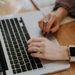 A writer drafting a post with an outline beside a laptop