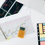 Research notes beside analytics on a laptop